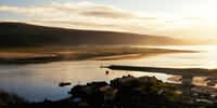 Evening view across Barmouth harbour and mouth of estuary from hill (Dinas Oleu) behind Barmouth: full size view=37K